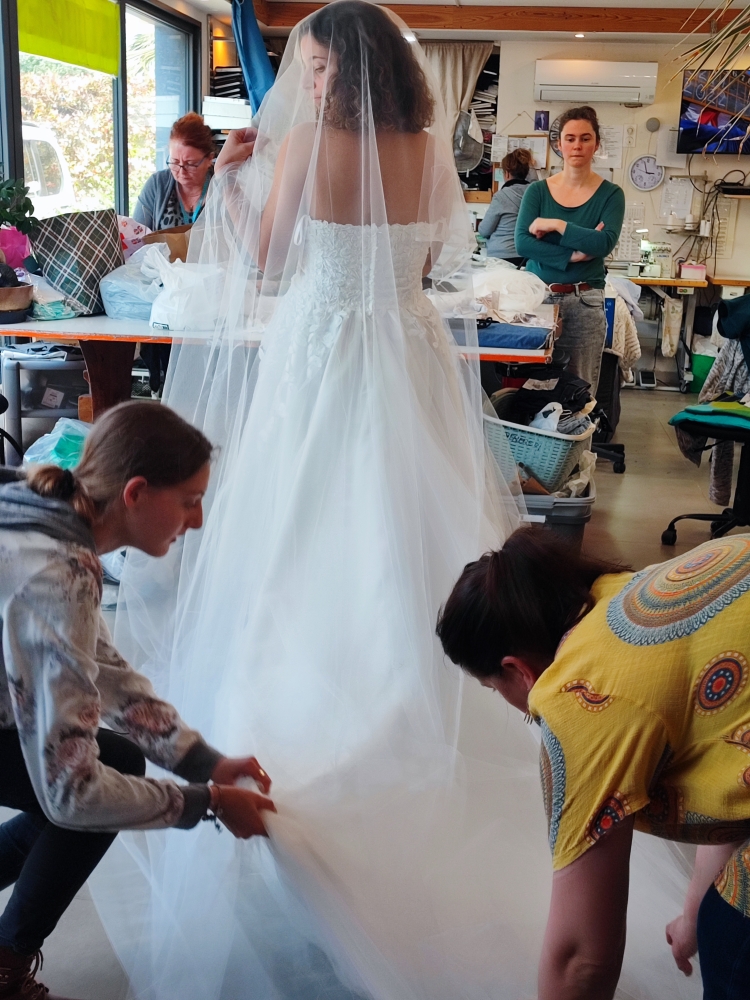 Essayage robe de mariée avec voile dans l'atelier