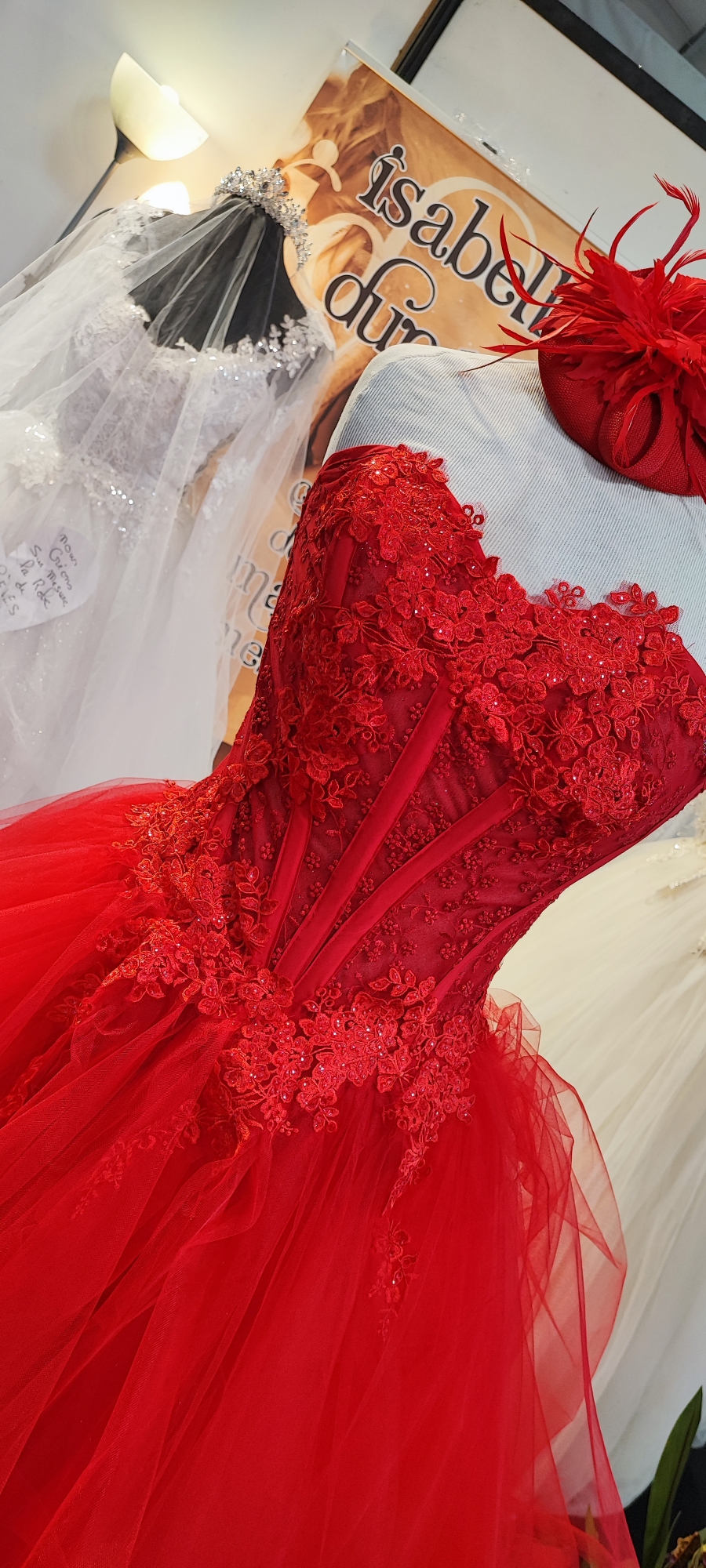 Détail robe rouge dentelle et chapeau sur mannequin